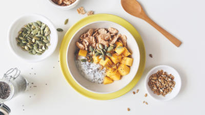 Birds eye view of pumpkin oatmeal, pumpkin seeds, chia seeds, and wooden spoon